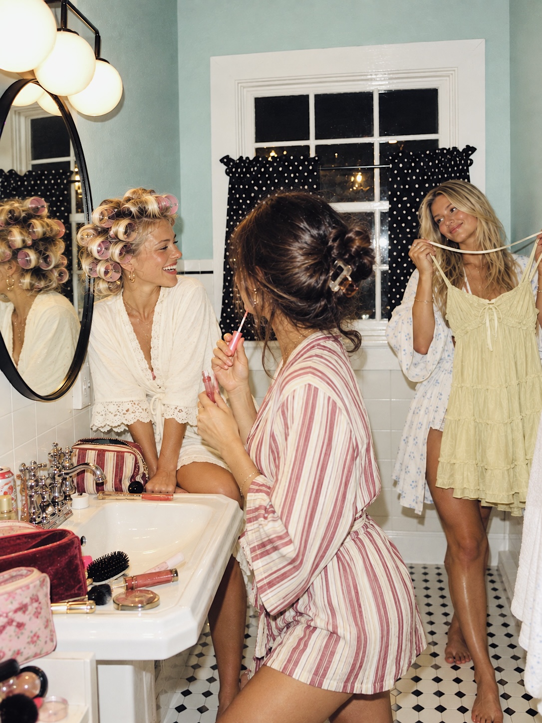 Friends getting ready together in the bathroom before a night out